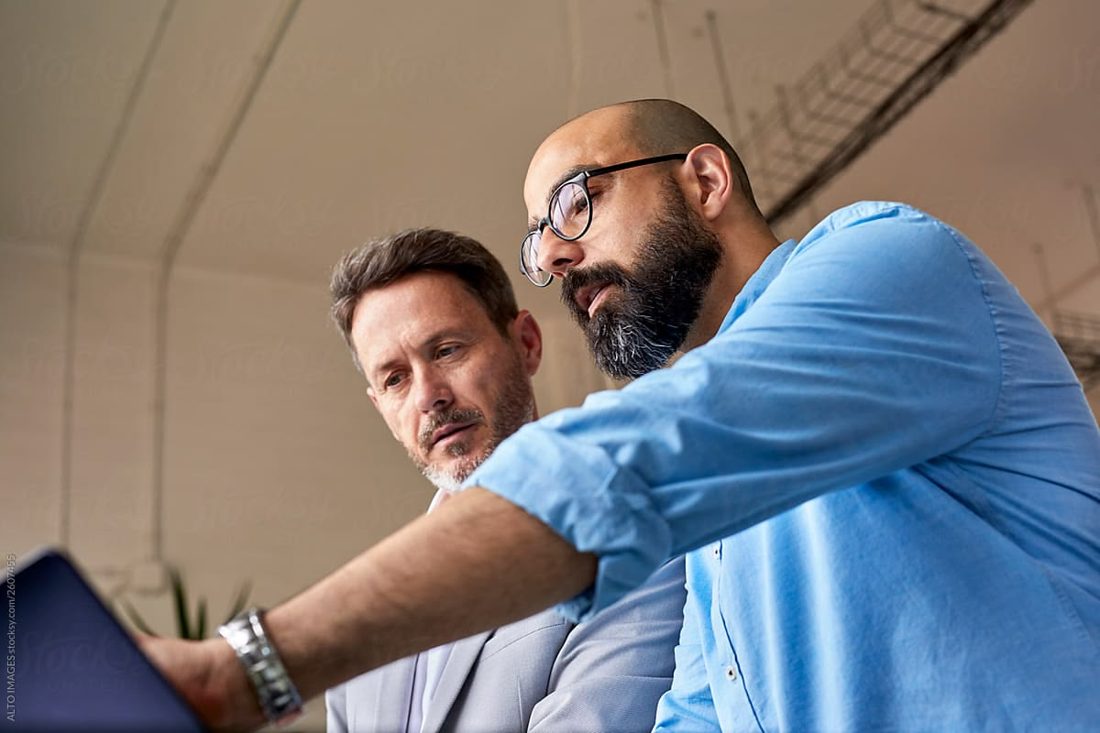 Two colleagues reviewing information on a tablet
